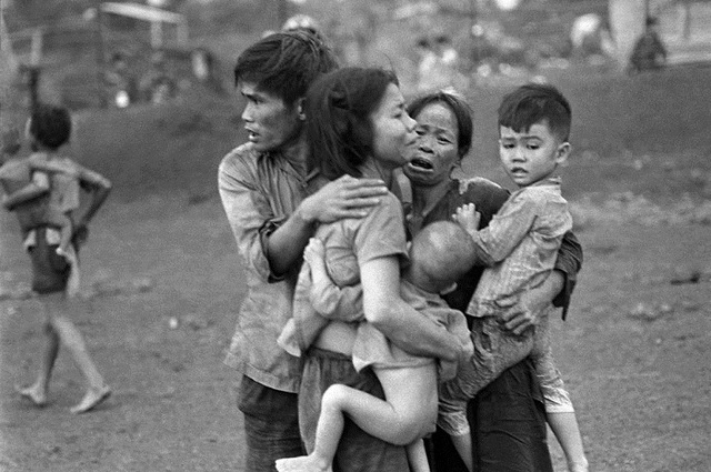 
	Một vài người dân miền Nam Việt Nam sống sót sau cuộc tấn công kéo dài 2 ngày đêm của quân đội Việt Nam cộng hoà nhằm chiếm chốt Đồng Xoài đang co cụm lại với nhau. Ảnh chụp tháng 6/1965.