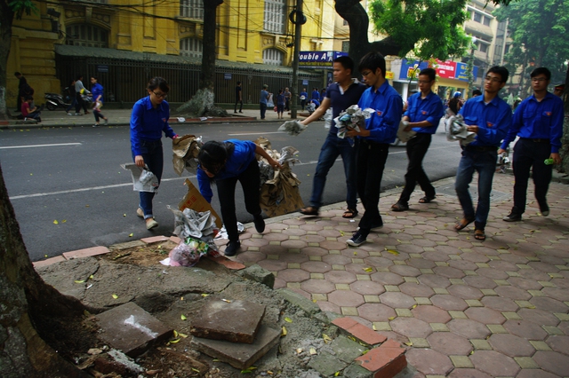 
	Thanh niên tình nguyện dọn dẹp rác trên con phố gần nhà tang lễ.