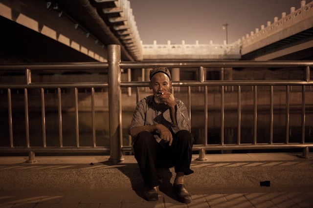  	Ông Nurdun Tuniyaz, 64 tuổi, người Duy Ngô Nhĩ, ngồi hút một điếu thuốc bên cạnh một con sông tại thủ đô Bắc Kinh. Băng ghế gỗ ở bờ sông này là chính giường ngủ của ông trong những ngày đi khiếu kiện.