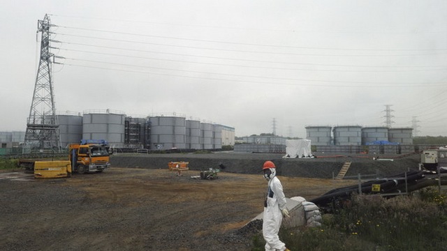 
	Một công nhân đứng cạnh các bể chứa nước ngầm ở nhà máy Fukushima.