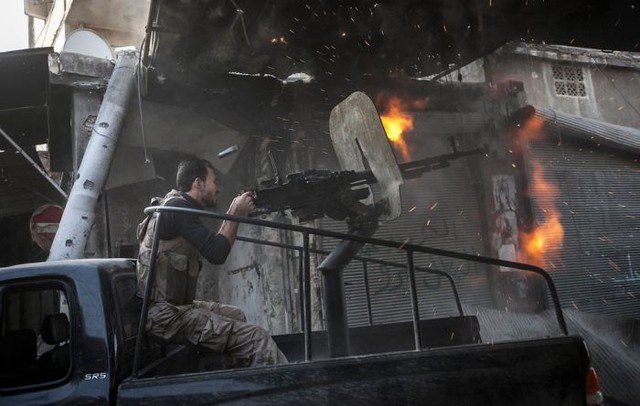 Quân nổi dậy bắn súng máy tự chế vào một tòa nhà nơi quân đội Syria trung thành với Tổng thống Assad đang ẩn náu trong một cuộc đụng độ lớn ở Aleppo (4/11/2012).