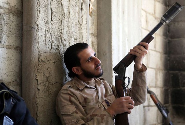 Một binh sĩ xem xét khẩu súng săn tự chế được sử dụng để bắn lựu đạn tự tạo tại Arabeen (9/2/2013).