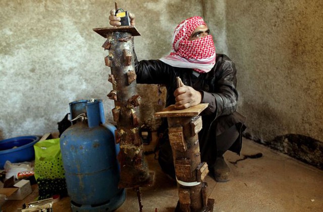Một chuyên gia chế tạo bom của quân nổi dậy Syria đang chuẩn bị kích hoạt trái bom (20/3/2012).