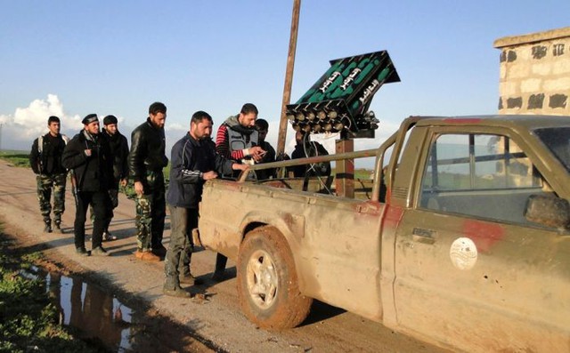 Các binh sĩ của quân nổi dậy Syria đứng cạnh vũ khí phòng không tự chế của mình ở gần sân bay quân sự Menagh (17/2/2013).