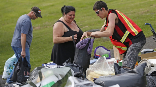 
	Những người dân mất nhà đến nhận quần áo cứu trợ ngày 7-7.