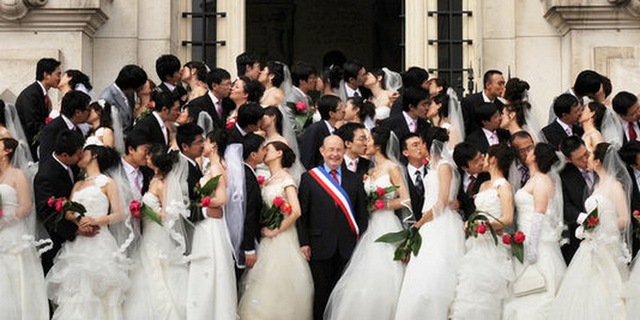 
	Thị trưởng Jean Germain (giữa) chụp ảnh cùng các cặp đôi người Trung Quốc vào năm 2009