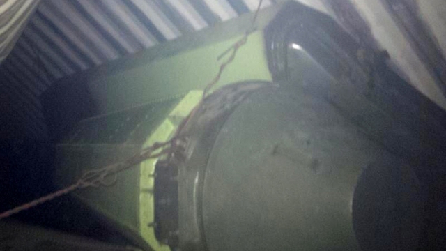	Một vật thể mang hình dáng tên lửa đạn đạo màu xanh lá cây nằm trên tàu Chong Chon Gang của Triều Tiên.
