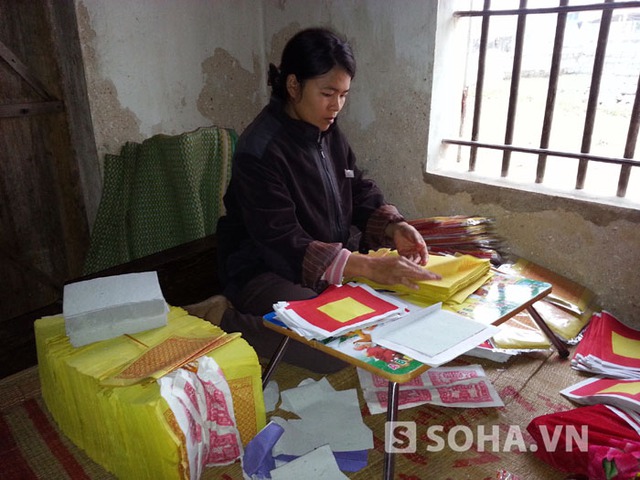 Chị Mai Thị Phượng (vợ của thuyền viên Hồ Vĩnh Thế) đang cố gắng đóng gói những tập vàng mã cuối cùng để kiếm tiền lo cho Tết.