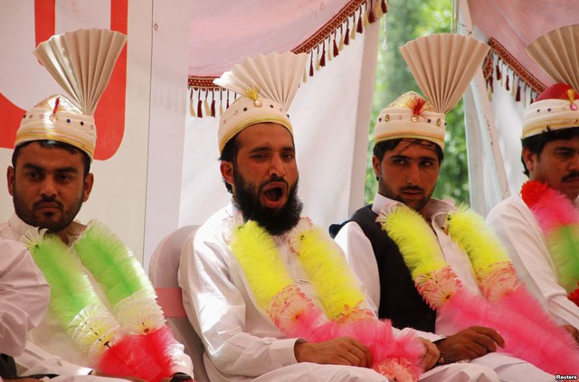 Một chú rể ngáp trong khi tham dự một đám cưới tập thể ở Peshawar, Pakistan.