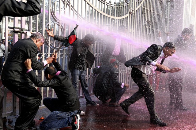 Mọi người bị cảnh sát sử dụng vòi rồng phun nước màu trong cuộc biểu tình ở Dhaka, Bangladesh.