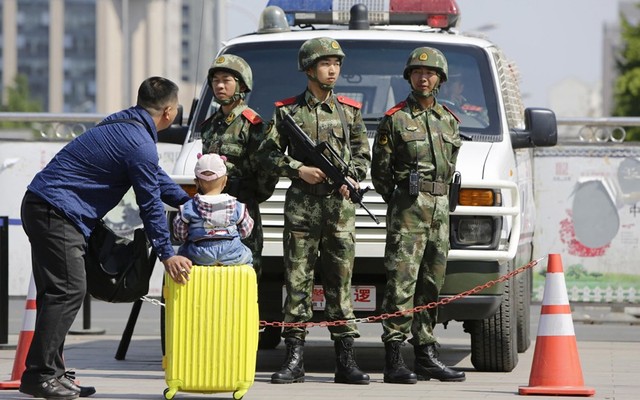 Cảnh sát bán quân sự trang bị vũ trang đứng bảo vệ tại nhà ga tàu hỏa Bắc Kinh sau vụ tấn công bằng dao khiến 6 người bị thương tại nhà ga tàu hỏa ở Quảng Châu, Trung Quốc.