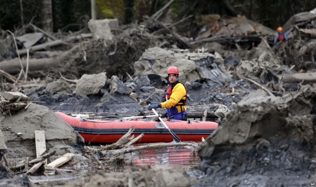 Một nhân viên cứu hộ sử dụng thuyền nhỏ để tìm kiếm nạn nhân tại hiện trường trận lở bùn ở Oso, Washington, Mỹ.