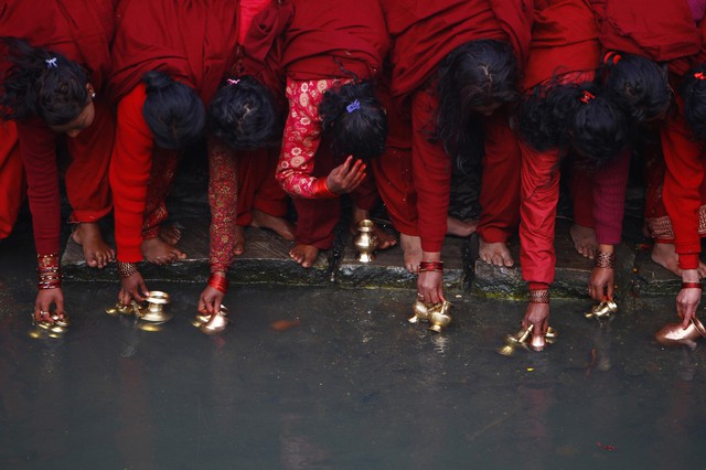 Những phụ nữ theo đạo Hindu múc nước thánh dưới sông Bagmati trong một lễ hội ở Katmandu, Nepal.