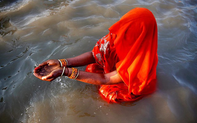 Một phụ nữ theo đạo Hindu cầu nguyện dưới sông trong ngày cuối cùng của lễ hội Magh Mela ở Allahabad, Ấn Độ.
