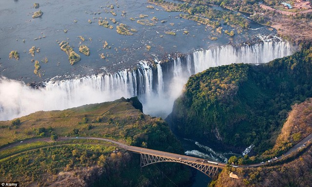 Victoria Falls, Zimbabwe / Zambia: Explorer David Livingstone đặt tên là thác nước của sông Zambezi sau khi Nữ hoàng Victoria, nhưng người dân địa phương gọi chúng là Mosi-oa-Tunya, nghĩa là khói sấm.  Nằm trên biên giới giữa Zambia và Zimbabwe, thác giảm mạnh 108m, tạo ra một màn sương có thể thấy từ 20 km đi