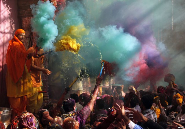 Các thầy tu đạo Hindu ném bột màu vào mọi người tham dự lễ hội Holi tại ngôi đền Bankey Bihari, Vrindavan, Ấn Độ.