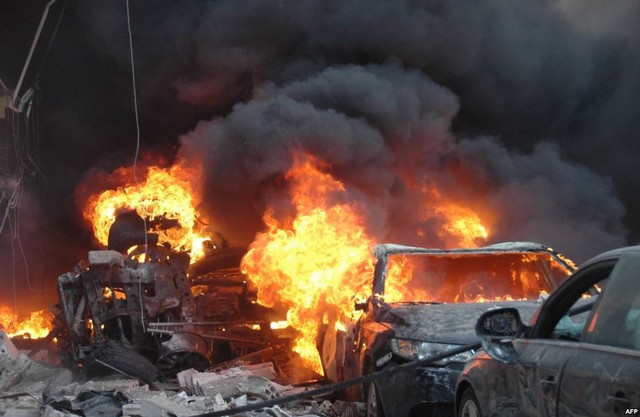 Những chiếc xe ô tô bốc cháy nghi ngút sau một vụ đánh bom xe trên đường phố ở Homs, Syria.