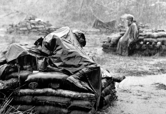 Lính Mỹ nằm nghỉ dưới cơn mưa nặng hạt ở Việt Nam. Ảnh của phóng viên Toshio Sakai.