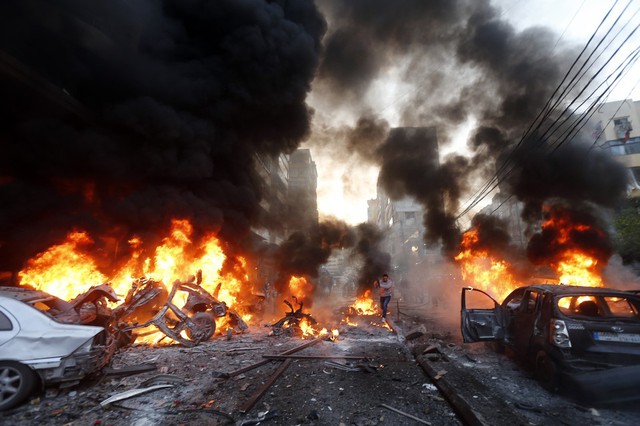 Khói và lửa bốc lên từ những chiếc ô tô sau vụ đánh bom ở Beirut, Li Băng.