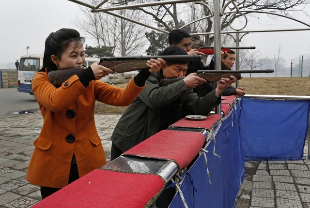 Khách thăm quan bắn súng hơi tại triển lãm súng gần sông Deadong, Bình Nhưỡng, Triều Tiên.