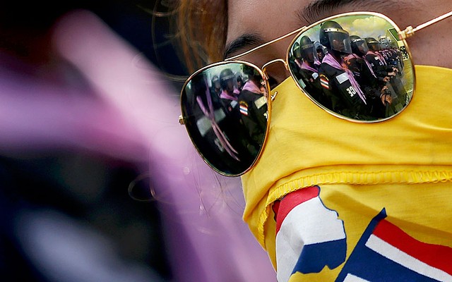 Cảnh sát chống bạo động phản chiếu trên kính chống nắng của một người biểu tình ở Bangkok, Thái Lan.