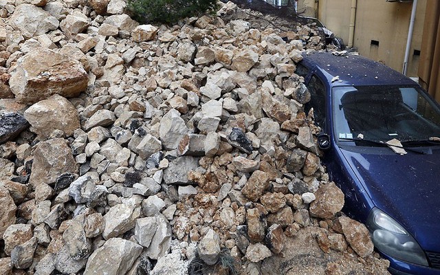 Một chiếc ô tô bị chôn vùi trong đá ở Nice, Pháp. Nhiều đoạn đường ở miền đông nam nước Pháp bị tắc do lở đất và lở đá.