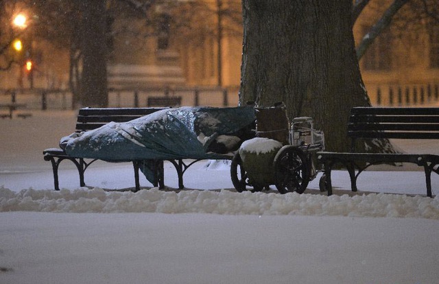 Một người vô gia cư ngủ dưới bão tuyết trên ghế ở ngoài Nhà Trắng, Washington, Mỹ.