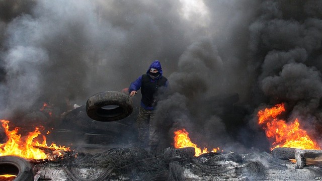 Một người biểu tình ủng hộ Nga đốt lốp xe để chuẩn bị chiến đấu với cảnh sát đặc nhiệm Ukraine ở ngoại ô thành phố Slavyansk.