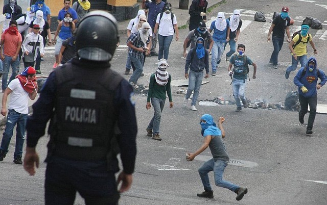 Người biểu tình chống chính phủ ném đá vào cảnh sát trước trường đại học Tachira, Venezuela.
