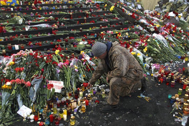 Một người đàn ông thắp nến tại khu tưởng niệm những người thiệt mạng trong cuộc đụng độ với cảnh sát ở Kiev, Ukraine.