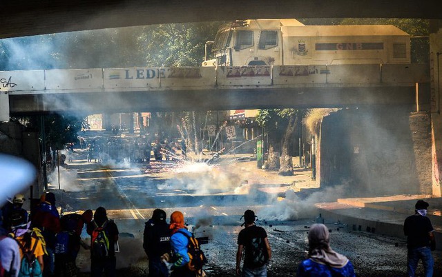 Cảnh sát bắn đạn hơi cay để giải tán người biểu tình chống chính phủ ở Las Mercedes, Caracas, Venezuela.