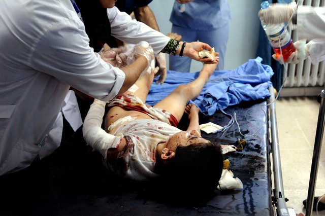 Các bác sĩ điều trị cho một cậu bé bị thương tại bệnh viện ở Damascus. Một loạt đạn cối đã nã vào thành phố sau khi Tổng thống Bashar al-Assad thông báo kế hoạch tranh cử Tổng thống Syria nhiệm kỳ ba.