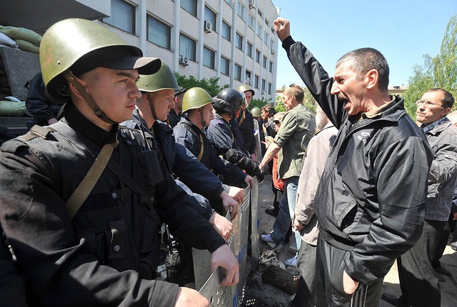 Những người biểu tình ủng hộ Nga hô khẩu hiệu phản đối trước cảnh sát Ukraine bảo vệ lối vào tòa nhà thị chính ở thành phố miền đông Mariupol.