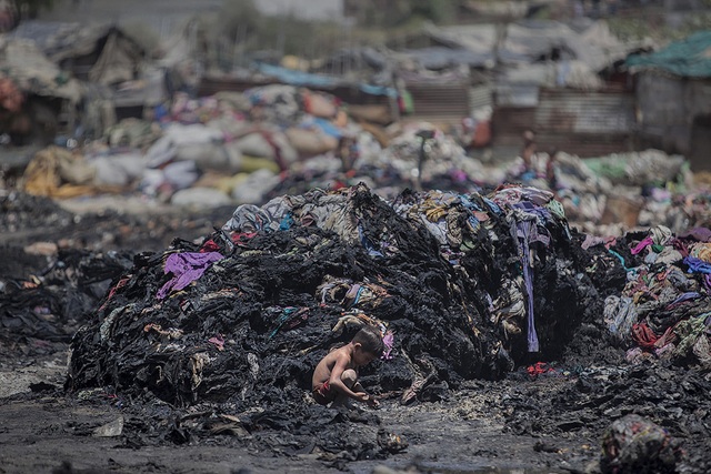 Một cậu bé tìm kiếm những mảnh kim loại giữ đống đổ nát sau vụ hỏa hoạn tại một khu ổ chuột ở Ghaziabad, ngoại ô New Delhi, Ấn Độ.