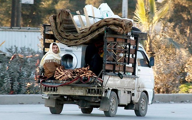 Một người dân ngồi cùng đồ đạc trên chiếc xe tải khi sơ tán khỏi các cuộc xung đột ở thành phố Aleppo, Syria.