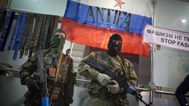 Những chiến binh ủng hộ Nga đứng bảo vệ một văn phòng của Cơ quan an ninh Ukraine ở Luhansk.