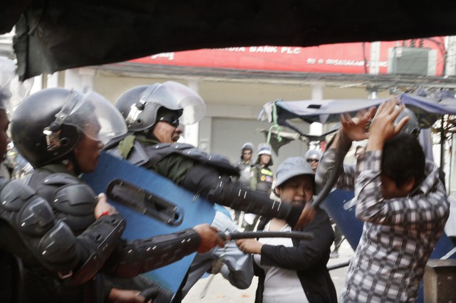 Cảnh sát chống bạo đồng dùng dùi cui đánh công nhân dệt may biểu tình ở Phnom Penh, Campuchia.