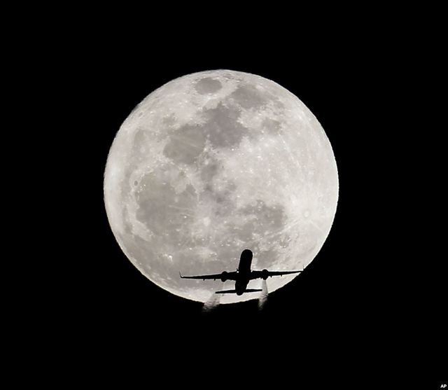Một chiếc máy bay thương mại in bóng lên Mặt Trăng khổng lồ trên bầu trời Whittier, California, Mỹ.