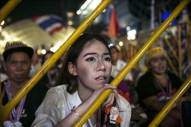 Một người biểu tình chống chính phủ chăm chú lắng nghe bài phát biểu của lãnh tụ Suthep Thaugsuban ở Bangkok, Thái Lan.