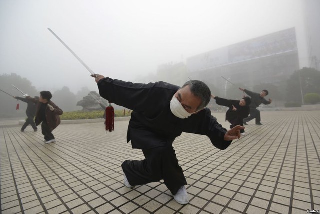 Một người đàn ông đeo khẩu trang tập thể dục buổi sáng do không khí ô nhiễm ở thành phố Phụ Dương, tỉnh An Huy, Trung Quốc.