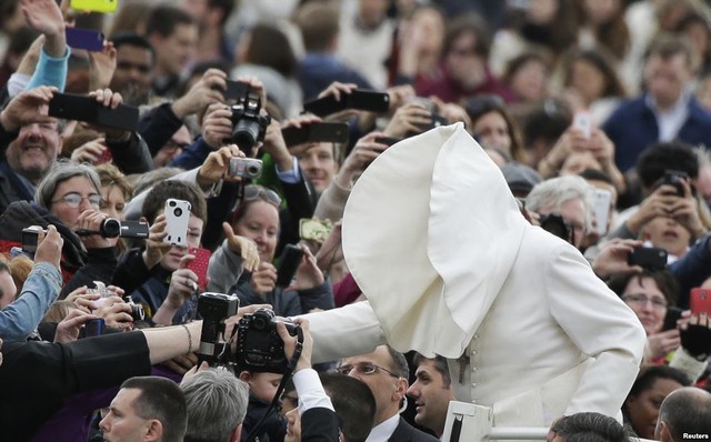 Gió mạnh thổi lật cổ áo của Giáo hoàng Francis khi ông đang bắt tay những người tham dự buổi thuyết giảng trên quảng trường Saint Peter, Vatican.