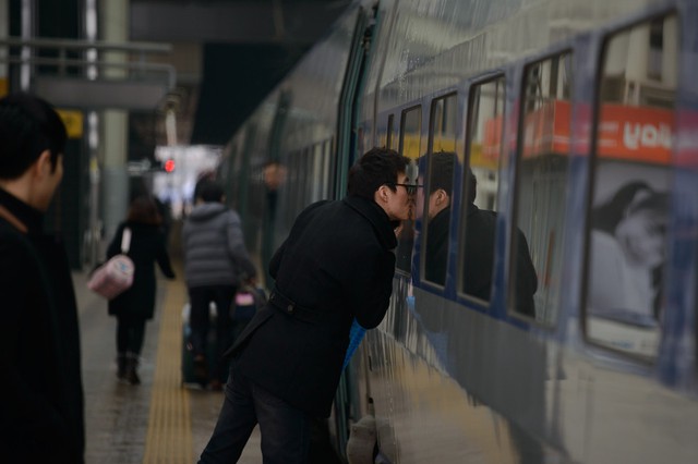 Một người đàn ông hôn cửa sổ kính tàu hỏa rời khỏi nhà ga ở Seoul, Hàn Quốc. Người dân Hàn Quốc đang tận hưởng kỳ nghỉ Tết Nguyên Đán.