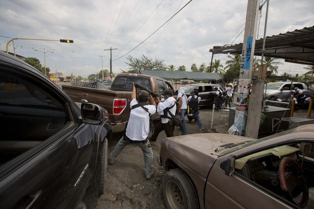 Những người đàn ông đang đấu súng với các phần tử của một băng nhóm mafia ở Nueva Italia, Mexico.