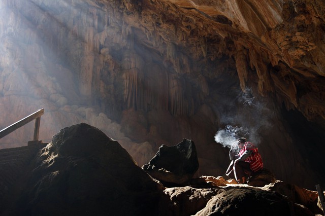 Một người đàn ông hút thuốc trong hang ở thị trấn Pa-An, Myanmar.