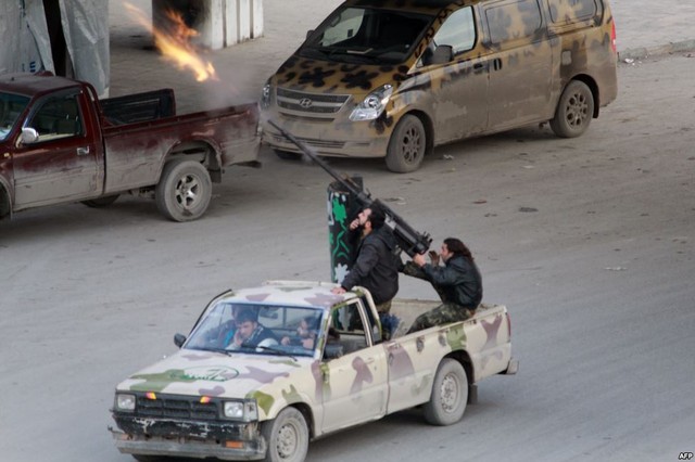 Các chiến binh phiến quân xả súng nhằm vào một máy bay của quân đội chính phủ bay qua phía bắc thành phố Aleppo, Syria.