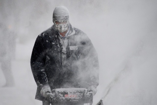 Một công nhân điều khiển máy thổi tuyết khỏi vỉa hè tại khu Brooklyn ở New York, Mỹ.
