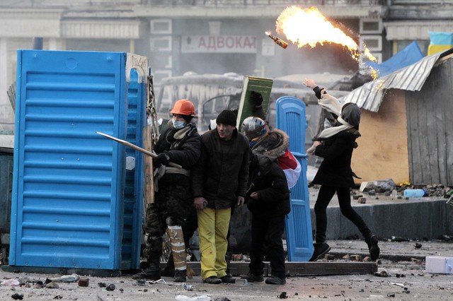 Người biểu tình dựng hàng rào chắn, đụng độ với cảnh sát chống bạo động trên đường phố ở Kiev, Ukraine.