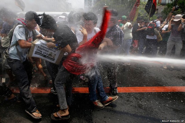 Cảnh sát dùng vòi rồng phun nước để giải tán người biểu tình trước đại sứ quán Mỹ ở Manila, Philippines. Người biểu tình phản đối chuyến thăm Philippines sắp tới của Tổng thống Mỹ Barack Obama.