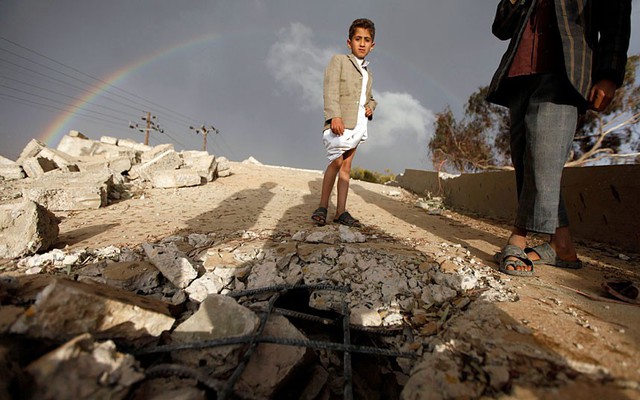 Một cậu bé đứng trên đống đổ nát của ngôi trường bị đánh bom bởi phiến quân Hồi giáo Shiite ở thủ đô Sanaa của Yemen.