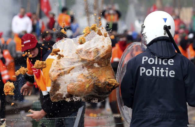 Người biểu tình vứt rác vào cảnh sát chống bạo động trong cuộc biểu tình của công đoàn EU phản đối các biện pháp khắc khổ ở Brussels, Bỉ.